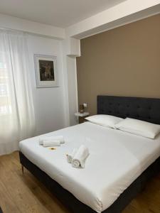 罗马Titina Suites Apartment Rome的卧室配有带毛巾的大型白色床
