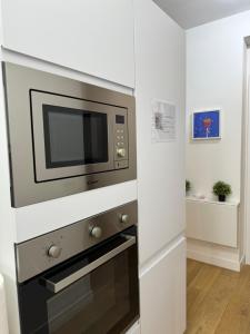罗马Titina Suites Apartment Rome的厨房设有白色墙壁和微波炉