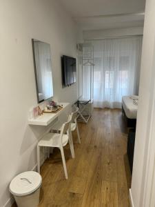 罗马Titina Suites Apartment Rome的客房设有带卫生间的书桌和床。
