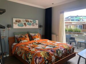 赞德沃特SEA MORE的一间卧室配有一张带橙色棉被的床和窗户