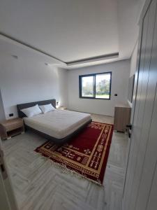 El AhmarThe Wave residence Chott Meriam Sousse的一间白色卧室,配有床和地毯