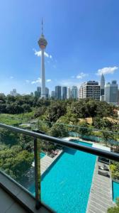 吉隆坡Suasana Bukit Ceylon Residence的阳台享有西雅图天际线的美景,设有游泳池。