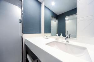 釜山ON:NA Hotel的浴室设有白色水槽和镜子