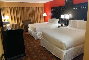罗歇尔公园帕拉默斯罗歇尔公园华美达酒店的酒店客房,配有两张床和椅子