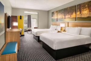 兰开斯特Days Inn & Suites by Wyndham Lancaster Amish Country的酒店客房配有两张床和一张书桌