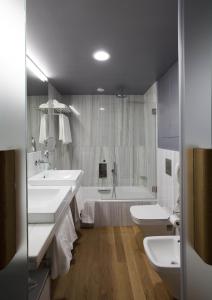 蒙特雷蒙特雷城堡酒店的一间带两个水槽、一个浴缸和两个卫生间的浴室