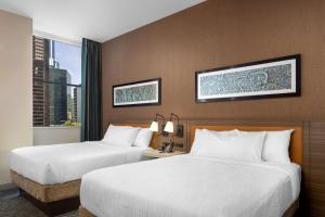 芝加哥Hilton Garden Inn- Chicago Central Loop的酒店客房设有两张床和窗户。
