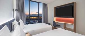 安塔利亚Hampton by Hilton Antalya Airport的酒店客房设有两张床和一台平面电视。