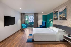 坎多林Hyatt Place Goa Candolim的配有一张床和一台平面电视的酒店客房