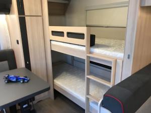 斯卡拉福卡斯Delightful RV Camper In a Peaceful Area near Sea.的小房间设有双层床和书桌