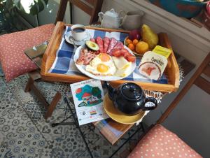 马拉加La Casa de La Abuela Rosy的桌上的早餐托盘,包括鸡蛋和水果