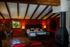 CastellnovoMasía Durbá B&B的一间设有床铺的卧室,位于一个红色墙壁的房间