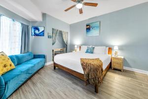 巴拿马城海滩Shores of Panama 1429的一间卧室配有一张床和一张蓝色的沙发