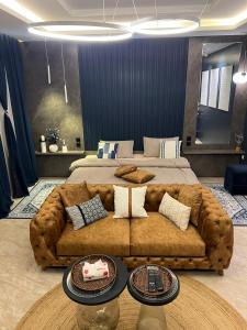 Al ‘Azīzīyahاستديو Studio Hometel VIP的卧室里一张大棕色沙发,配有床