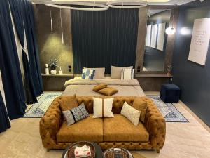 Al ‘Azīzīyahاستديو Studio Hometel VIP的一间卧室配有一张大床和棕色沙发