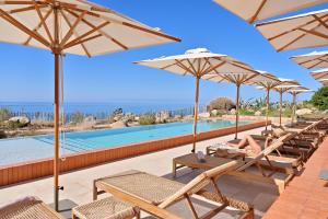 奥尔梅托阿巴特罗酒店的一组椅子和遮阳伞,位于游泳池旁