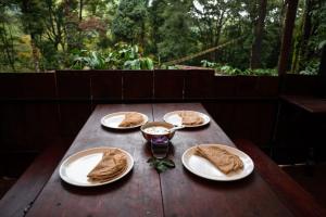 瓦亚纳德Jungle Woods 900kandi的一张木桌,上面有四盘食物
