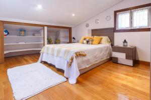 莱萨卡Casa Otxotenea的一间卧室设有一张大床,铺有木地板