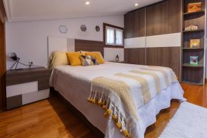 莱萨卡Casa Otxotenea的一间卧室配有一张带条纹毯子的大床
