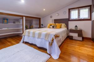 莱萨卡Casa Otxotenea的一间卧室设有一张大床,铺有木地板