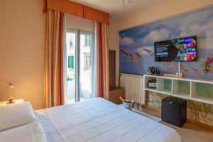 佛罗伦萨简酒店的一间卧室配有一张床,墙上配有电视