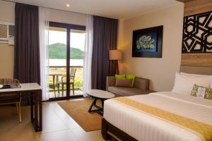 科隆Zuri Resort的酒店客房设有一张床、一张书桌和一个阳台。