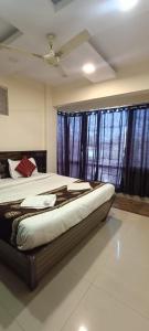 纳威孟买New Phoenix By Glitz Hotels的一间卧室配有一张带吊扇和窗户的床。