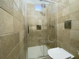 维耶斯泰Uria Rooms & Suite B&B的带淋浴、卫生间和盥洗盆的浴室