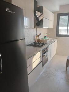 拉古莱特Tunisia la goulette的厨房配有黑色冰箱和炉灶。