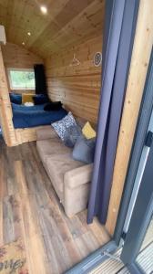 邓加文The Peregrine - 2 Person Luxury Glamping Cabin的一个小房子内的一个沙发