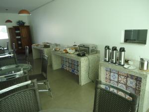 古鲁皮Hotel Jequitibá的餐厅设有椅子和食品柜台。