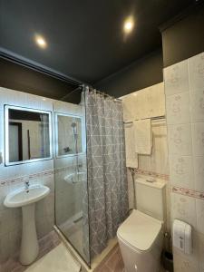 地拉那Misk Hotel & Resort的带淋浴、卫生间和盥洗盆的浴室