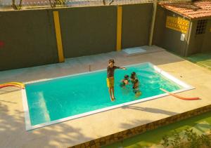 博阿维斯塔Suíte Luxo Contêiner的游泳池里的一个男人和两个孩子