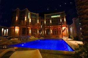 达哈布NEOM DAHAB - - - - - - - - - - - Your new hotel in Dahab with private beach的一座游泳池,在晚上在建筑物前