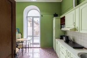 利沃夫索博尼旅舍的厨房设有绿色的墙壁和桌椅