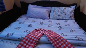 Sekenaniorkaria safari mara camp的一张带红白色拼盘床单和枕头的床