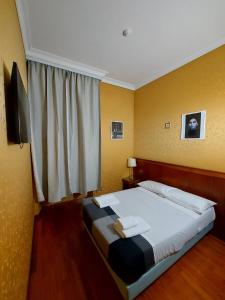 罗马Hotel Positano 2的一间卧室设有一张大床和窗户