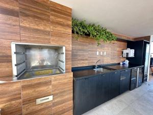 萨尔瓦多Edificio Nau no coração da Barra的厨房配有水槽和带壁炉的柜台。