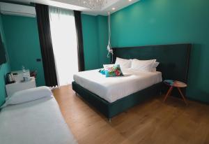 佩斯卡拉Aron Only Suites Bed and Breakfast的一间卧室设有一张大床和蓝色的墙壁