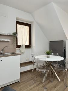 蒙泰内罗迪比萨恰Stanze Borgo Antico的白色的厨房配有桌椅和窗户