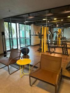 圣保罗Studio Premium Ibirapuera的健身房内带两把椅子和一张桌子的房间