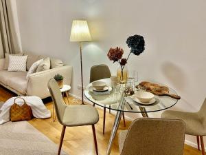 维也纳Zentrales Apartment mit Balkon的客厅配有玻璃桌和椅子
