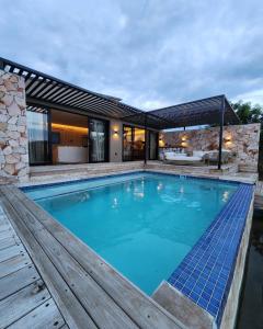 索赫燕杜Lira Boutique Lodge的一个带木制甲板和房子的大型游泳池