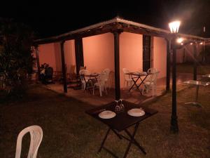 ItatíHotel Octavio的夜晚在房子前面的一张桌子和椅子