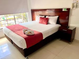 波哥大Hotel Dorado Gold的一间卧室配有一张大床,里面装有2盒