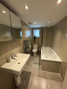 布伦特福德Brentford Guest Rooms的一间带水槽、浴缸和卫生间的浴室