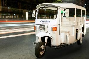 曼谷齐隆中心点酒店 的沿着街道行驶的一辆白色高尔夫球车