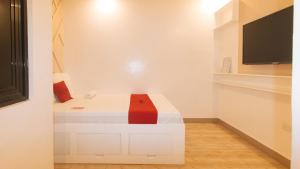达沃市RedDoorz @ Innzz Apartel的白色的客房配有一张带红色枕头的床