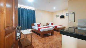 达沃市RedDoorz at Casa Buena Dormitel Davao City的酒店客房设有两张床和盥洗盆