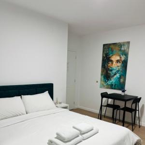 佩尔梅特Viva Apartments的卧室配有白色的床和墙上的绘画作品